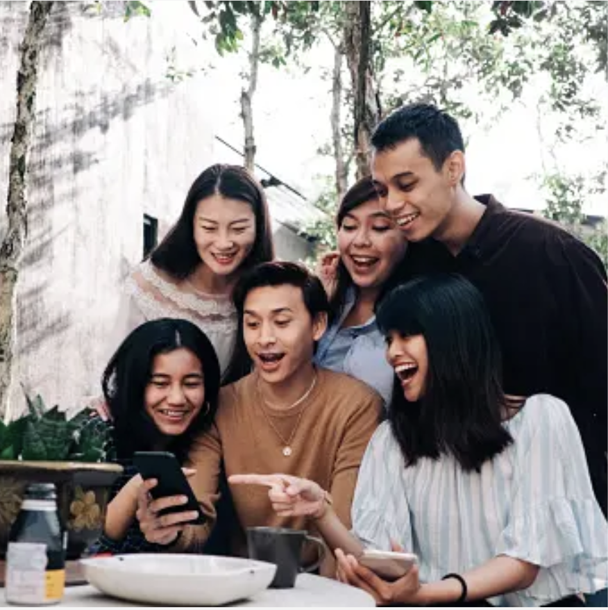 Group of friends looking at a phone, sharing a moment